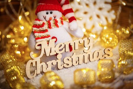Merry Christmas greetings - text in vintage letterpress wood type on a grunge wooden background with garlands and snowmanの写真素材