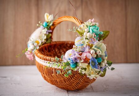 Designer basket is decorated with flowers. Wicker basket for celebrating Easter and other holidays....