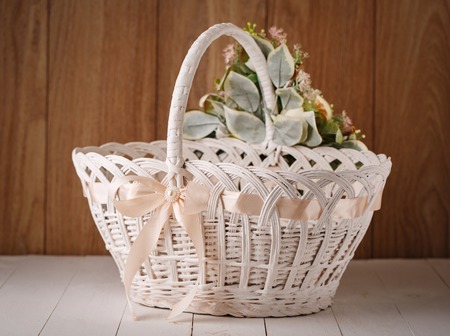 beautiful decorative basket with flowers to celebrate Easter on a wooden backgroundの写真素材