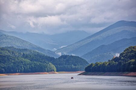 Mountain lake. The lake between the rocks. Wonderful valley. Hiking and Tourism Concept. hdr. Boat with tourists floats lake. Sea walk.の写真素材