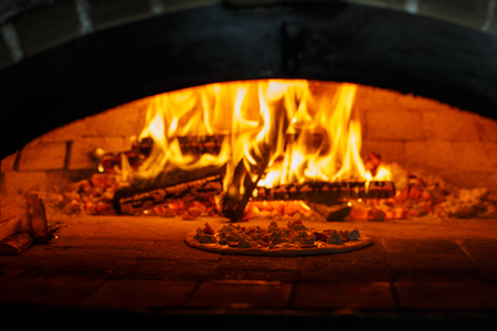 Flame in the furnace. Aromatic pizza in the baking process