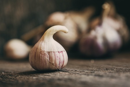 Garlic in a wooden box. Garlic with a curved tail.の写真素材