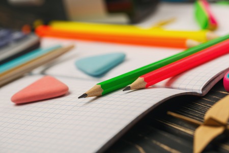 Bright crayons lie on a notebook on the background of the stationeryの写真素材