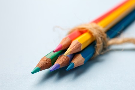 Five bright wooden crayons lie on a blue backgroundの写真素材