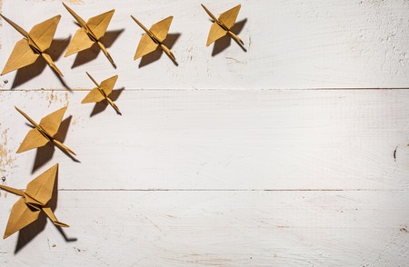 White wooden background with origami. Background for the text.の写真素材