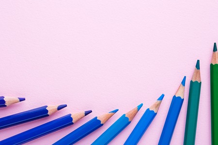 A group of bright pencils on a pink backgroundの写真素材