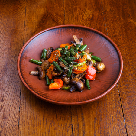 Stewed vegetables in the restaurant. On a wooden tableの写真素材