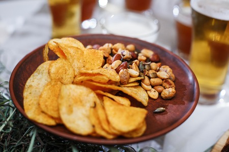 Delicious snacks for beer. Crispy chips with nutsの写真素材