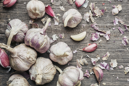 Garlic with husk on a wooden background. Top viewの写真素材