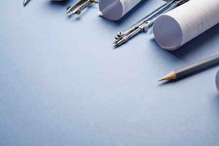 Tools for drawing and rolls of blueprints on a blue backgroundの写真素材