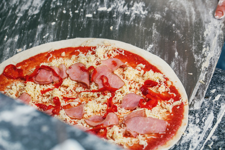 Pizza with bacon on a wooden blade
