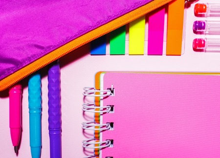 Pink notebook with pens on a pink backgroundの写真素材