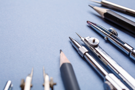 Compasses and pencils on a light blue background. 1 September concept postcard, teachers day. selective focus. Flat lay, place for text.の写真素材