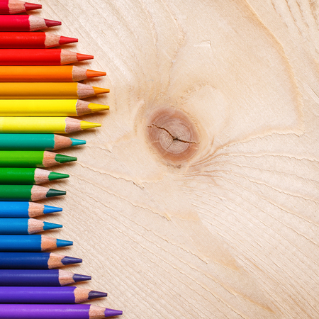 Pencils in rainbow color wave laid on wooden background. Top view, flat lay. copyspaceの写真素材