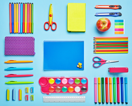 Group stationery set forth in composition on a blue background. Top view, flat lay. copyspaceの写真素材