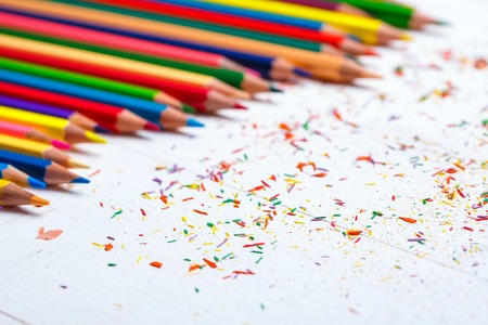 A group of bright wooden pencils on a white background. Abstract background from color pencils. Drawing supplies: assorted color pencilsの写真素材