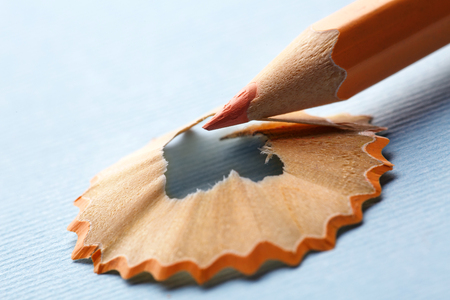 Orange pencil with a shavings on a blue background. Educational backgroundの写真素材