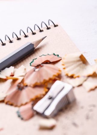 A notebook, a sharpener, shavings and pencils on a white background.Drawing with pencils. selective focusの写真素材