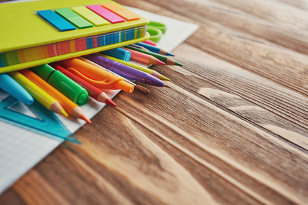 Education concept. Pens, pencils, markers, ruler and brush on notebook. on a wooden background. flat layの写真素材