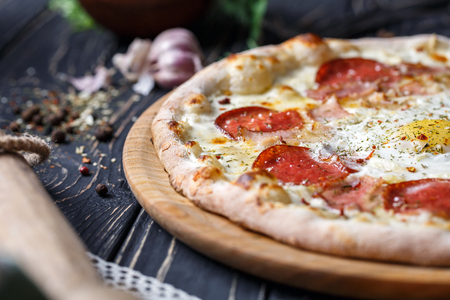 Aromatic pizza with egg and sausage. A fragment of pizza. Background ready for your design. Pizza on a black backgroundの写真素材