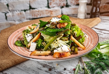 Concept promotional flyer. Refreshing salad of cabbage, green beans, mozzarella and fried potatoesの写真素材