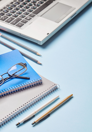 Workplace of the secretary - notebook, pen, sharpener and loptop. Group of school supplies on tableの写真素材