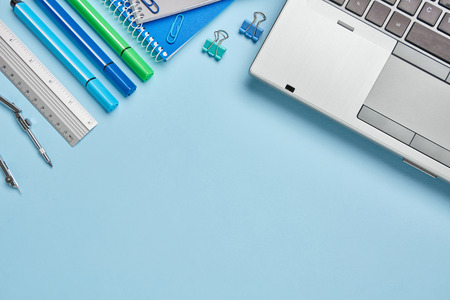 A notebook next to a school stationery on a blue background. Stationery with copyspace. Top view, Flat lay. copyspaceの写真素材