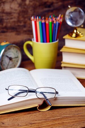 An open book with eyeglasses in the libraryの写真素材