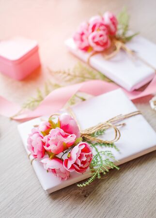 Composition with gift boxes decorated with green branch and rose.の写真素材