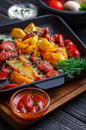 Potato baked with sausages and decorated with herbs.の写真素材
