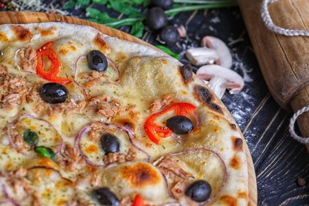 Pizza with fish, olives, onions and tomatoesの写真素材