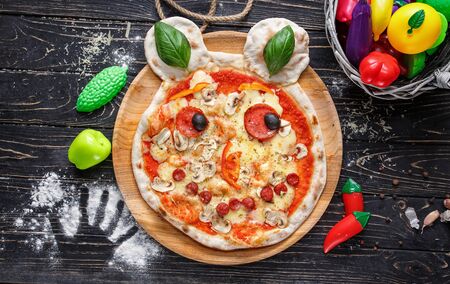 Baby pizza in the form of a bear with sausages, mushrooms and basil leaves. Concept promotional flyerの写真素材