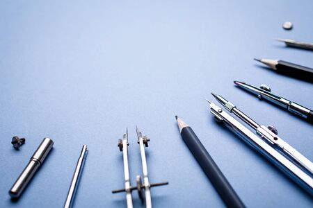 Tools for drawing blueprints laid out in a semicircle on a blue background. 1 September concept postcard, teachers day. Background ready for your design. selective focus. Flat lay, place for text. Top viewの写真素材