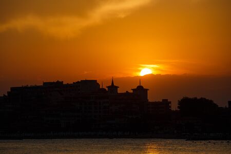 Golden sunset on the beach. Silhouette of the city. Beautiful architecort by the sea on the background of the sunset. Calm and travel concept. Sveti Vlas, Bulgaria. Sunny Beachの写真素材