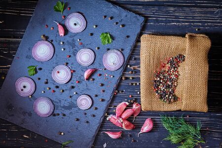 Pepper peas scattered chaotically on the board with onions. On the board components for the marinade. Top view.の写真素材