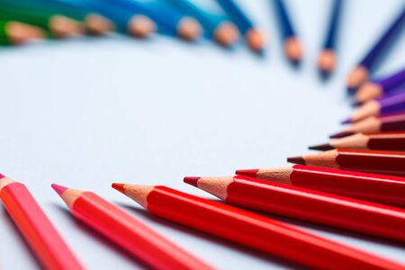 A group of bright wooden pencils on a blue backgroundの写真素材