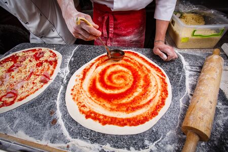 Pizza in the cafe. Tomato paste on the doughの写真素材