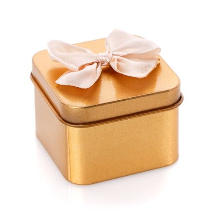 Single gold gift box with bow isolated on white backgroundの写真素材