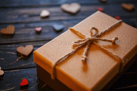 Brown gift boxes on wooden background with a bow of a simple rope closeup. Love, celebration and gift concept.の写真素材