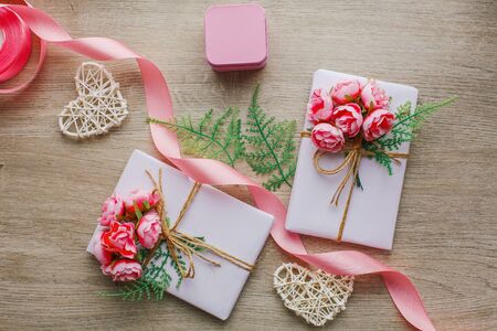 Eco style gift wrapping. Composition with gift boxes decorated with green branch and rose. Top view, flat layの写真素材