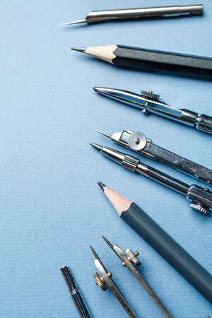 Drawing tools are arranged on a blue background. The set of elements reflecting the concept of engineering and design. Flat lay, place for text.の写真素材