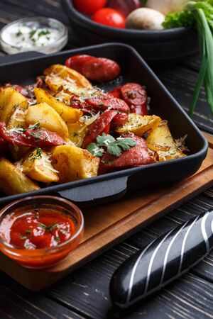 Baked potatoes along with vegetables and sauces. On a black wooden backgroundの写真素材