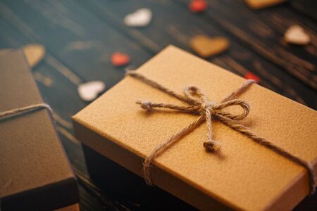 Two brown gift boxes on a wooden background with a bow of a simple rope on wood backgraund. Mother's day. Women's day. Valentine's day, Birthday greeting concept background.の写真素材