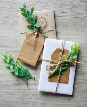 Composition with natural style handcrafted gift boxes, floral decor elements and rustic twine bow on wooden background.の写真素材