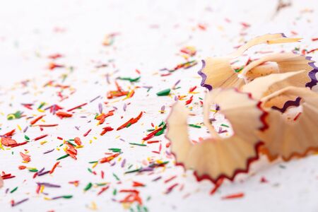 Shavings from colored pencils on a white background. Educational background. Background ready for your designの写真素材