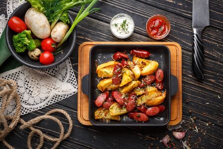 Concept promotional flyer. Baked potatoes along with vegetables and sauces. On a black wooden background. Flay lay. Top viewの写真素材