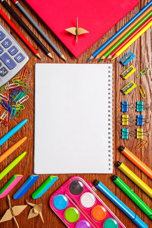 Stationery is presented in the form of a cross - in the center a place for text. On a wooden background. Top view, flat lay.の写真素材