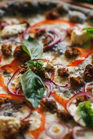 A basil leaf close up on a pizza. Delicious background.の写真素材