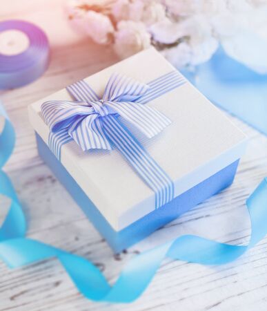 Gift box with blue ribbon and bow.Christmas presents in decorative boxes. Greeting for Birthday, Womens or Mothers Day. Holiday concept. Close up, background, copy, top view.の写真素材