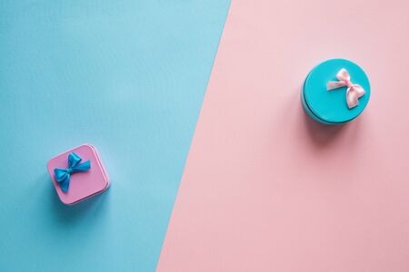 Top view blue gift box on a pink background and pink gift box on a blue background creative festive flat layの写真素材
